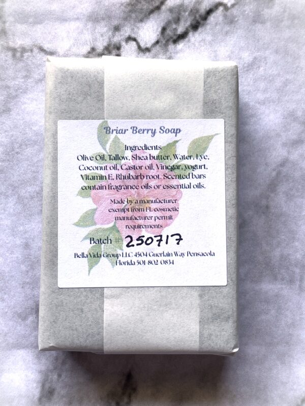 Back label of a bar of Bloom bath soap on white and black marble.