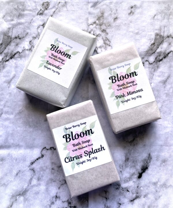 3 bars of Bloom bath soap on a white and black marble background.