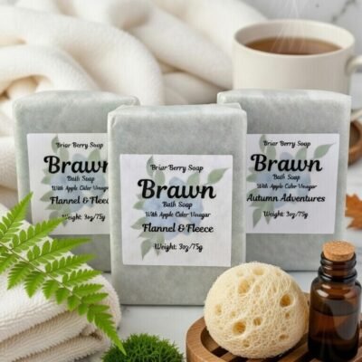 Three bars of Brawn bath soap on white marble surrounded by spa items.