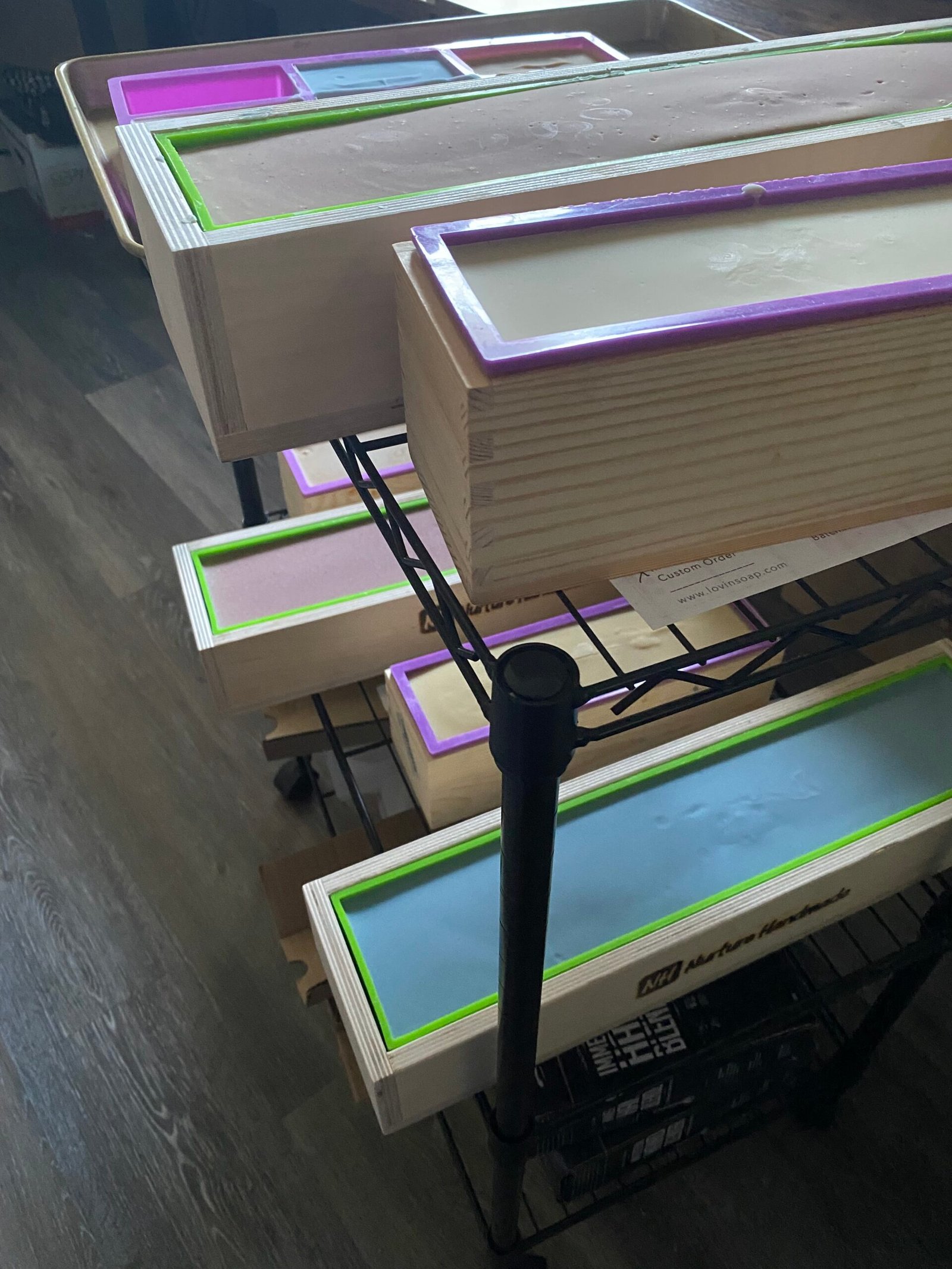 Loaves of soap in the molds on a large rolling rack waiting to be cut into bars.